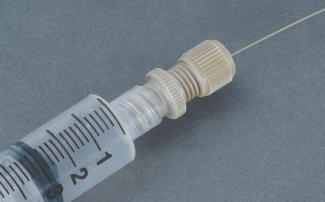 Photo of IDEX Luer-to-Microtight PEEK adapter P-662 connected to a syringe